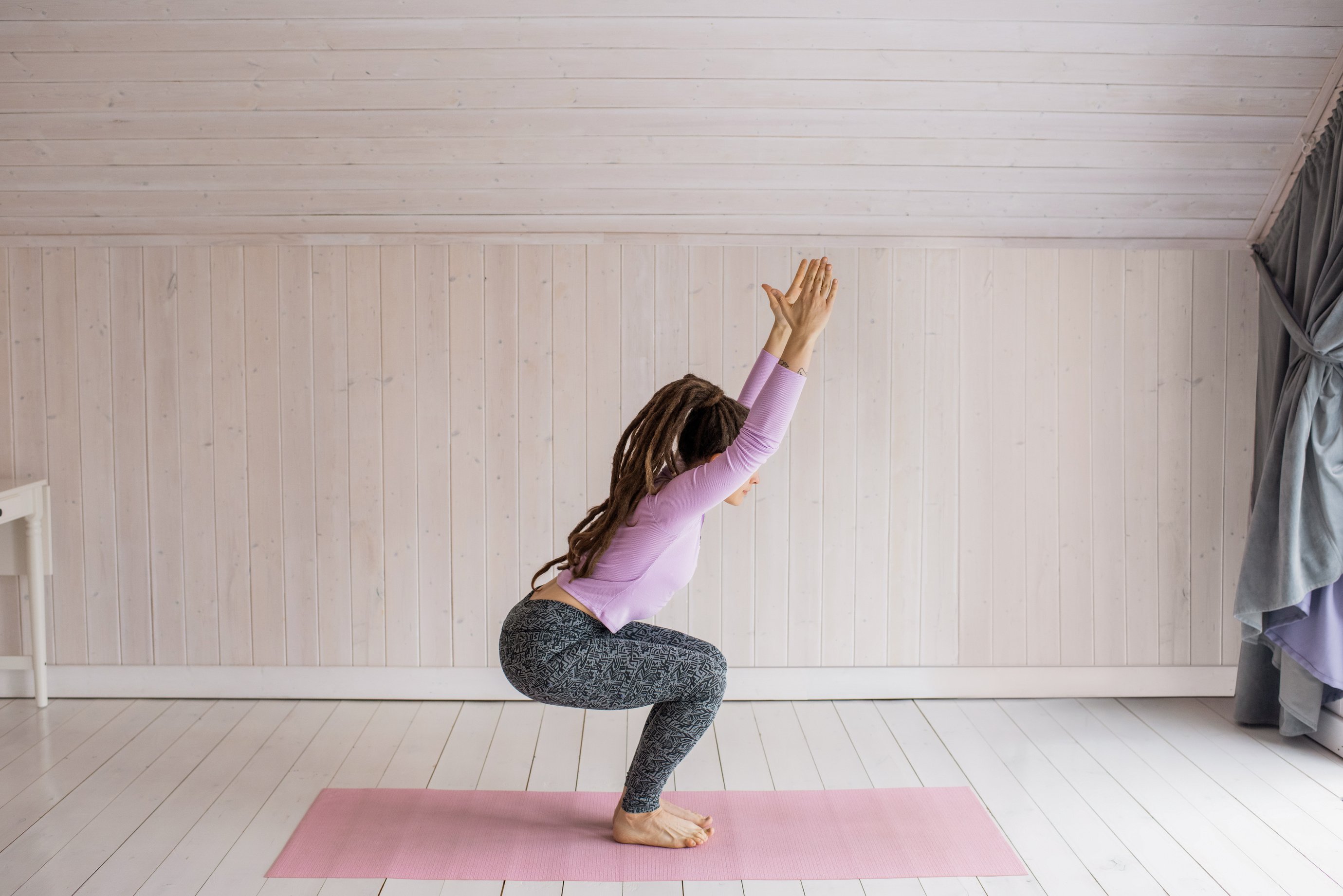 Woman In Purple Long Sleeve Shirt And Grey Leggings Working Out